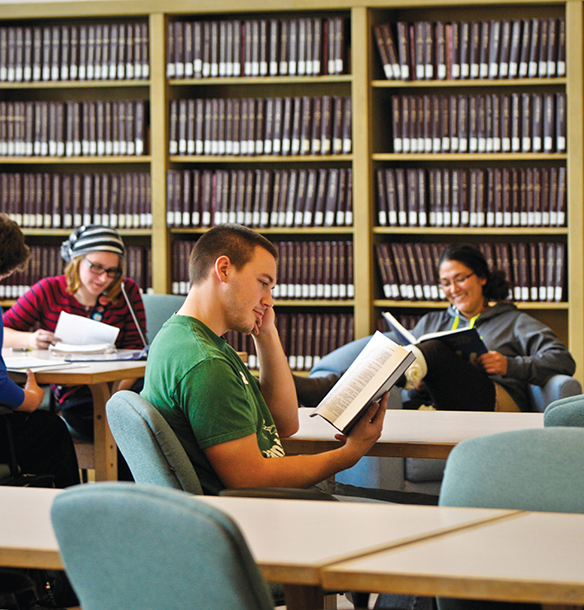 MSJ students sitting at desk in library studying.