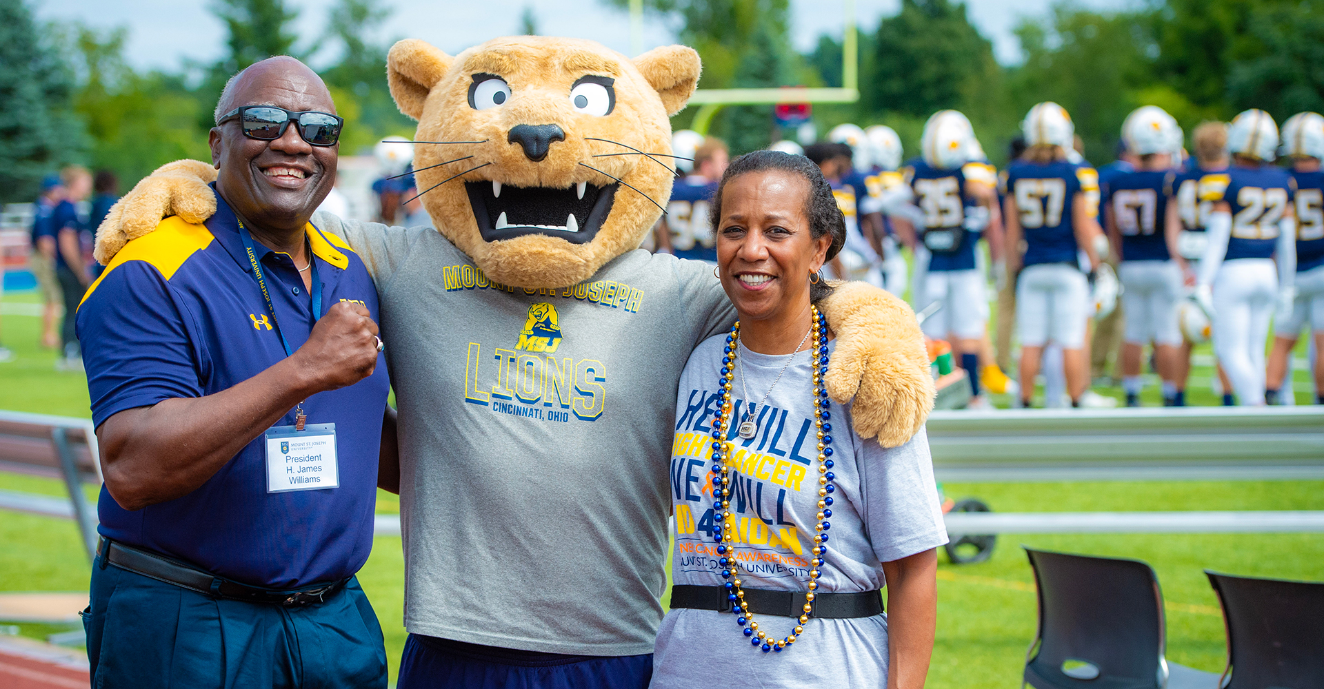 president and carole williams at football game with mascot