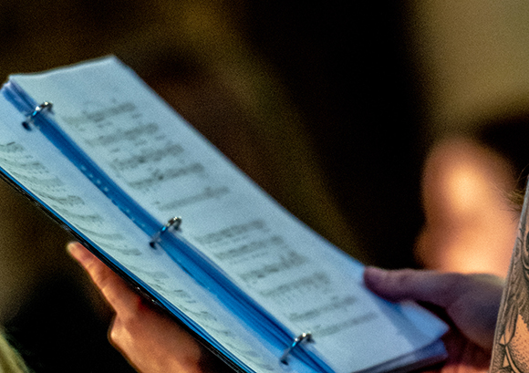 A person holds open a choir book