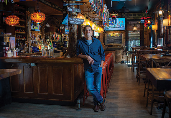 Mount St. Joseph alumnus juan imeroni standing next to bar at Che's in Over the Rhine. 