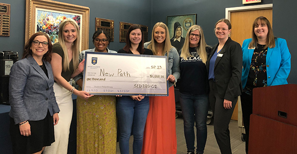 Mount St. Joseph student philanthropy group holding check for non profit