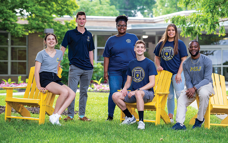 undergraduate students standing next to each other in the quad smiling