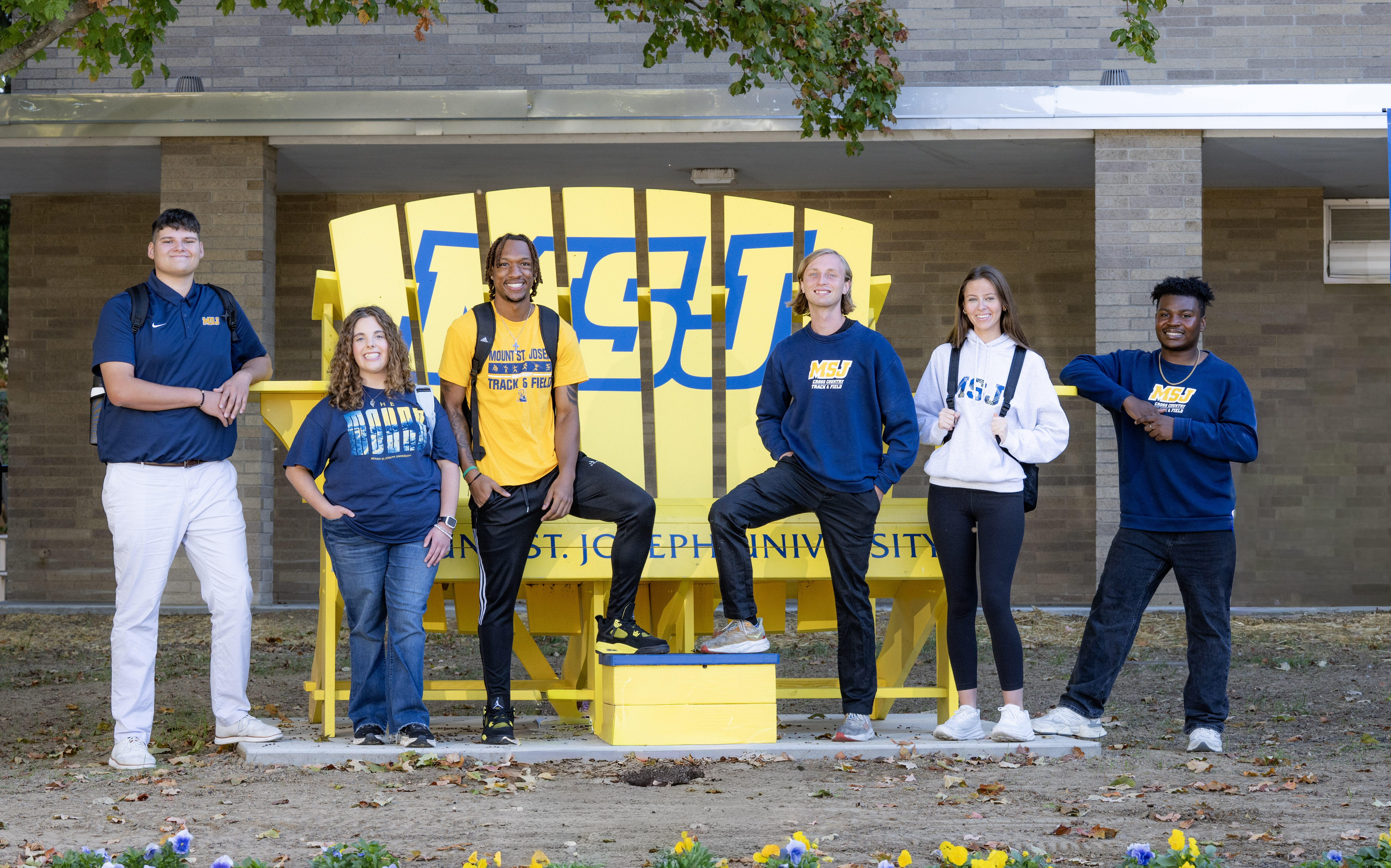 msj students smiling by big yellow chair