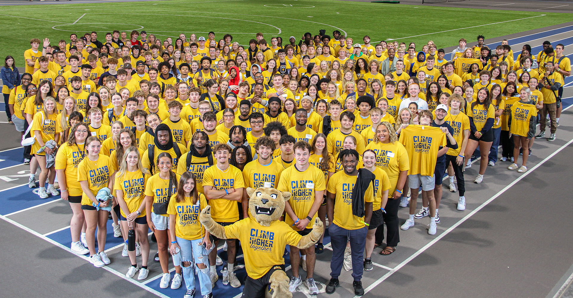 students at orientation smiling in group with joe lion mascot