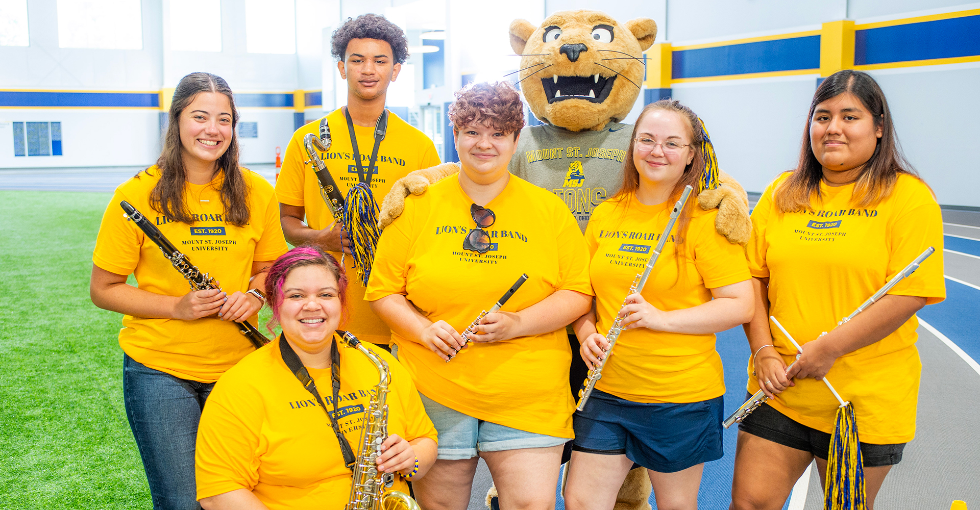 students at orientation smiling in group with joe lion mascot