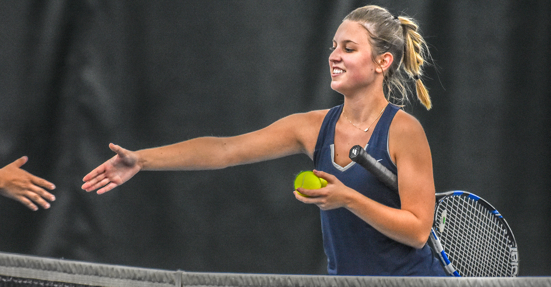 female tennis player shaking hands with opponent