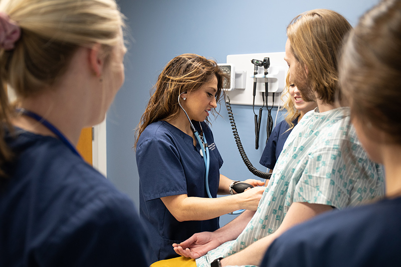 nursing student using stethoscope on a pretend patient