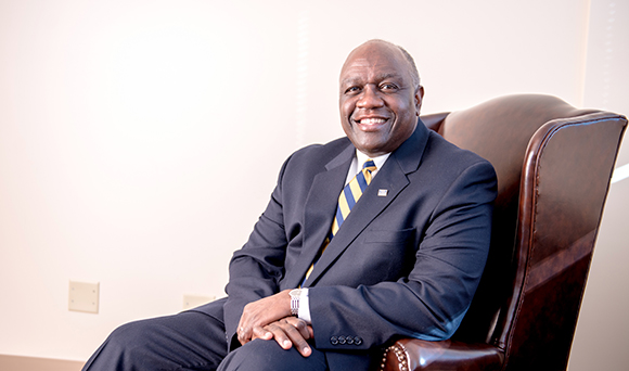 president williams sitting in chair smiling