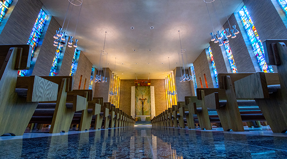 mater dei chapel with stained glass windows and pews