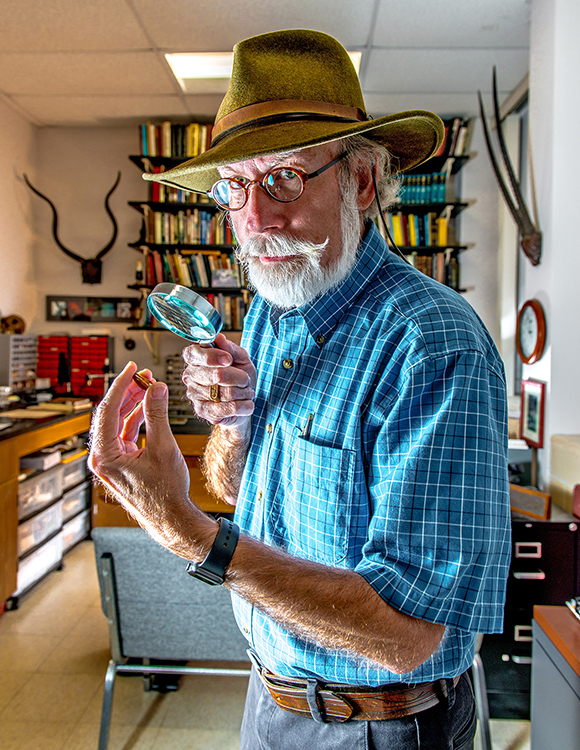 professor holding a magnifying glass