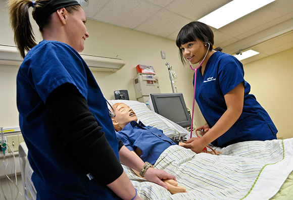 two nurses monitoring sim lab patient
