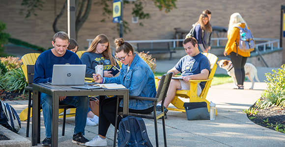 MSJ students in quad of Mount St. Joseph University studying for exams at table.