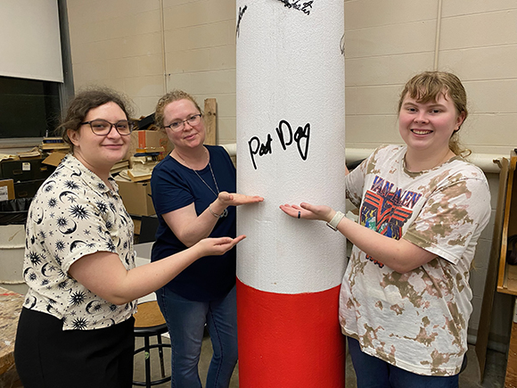 students next to red's sculpture