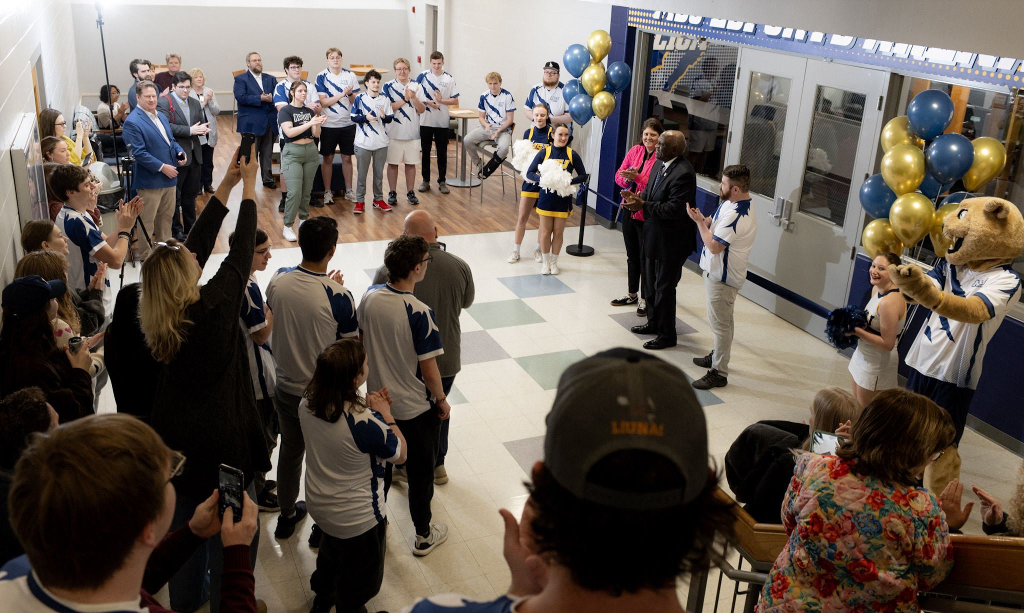 people by an esports room with ribbon cutting